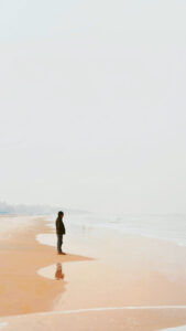 Dekoratives Bild: Mann steht am Meer und schaut in die Weite