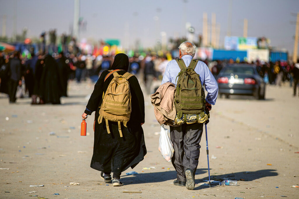 Alter Mann und alte Frau gehen über eine Straße im Orient