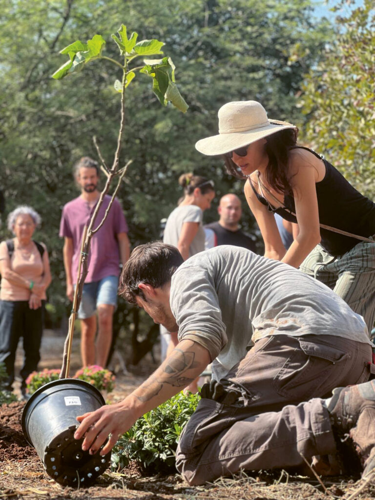 Baumpflanzung in Israel, ein Mann im Vordergrund ist dabei den Baum zu pflanzen, andere schauen zu